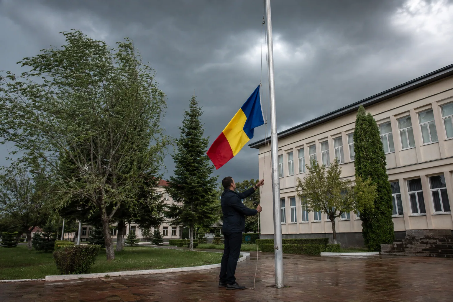 Operator care coboară drapelul României înaintea unei furtuni